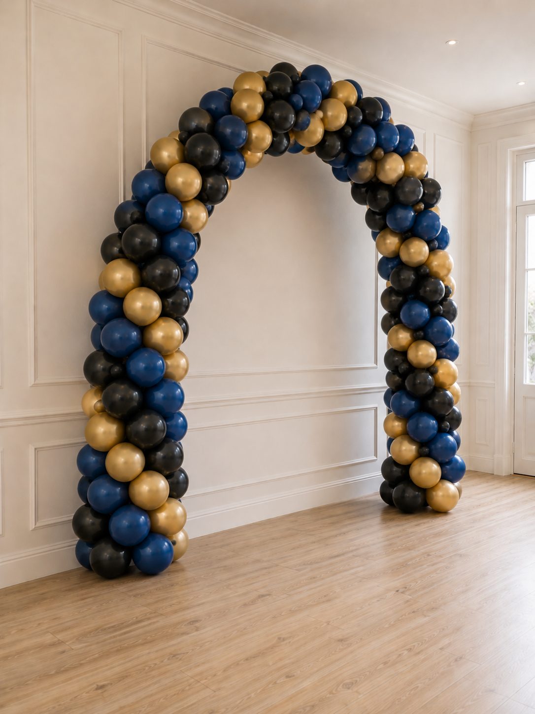 Arco de globos en azul marino, negro y oro montado por Haru Deco en un salón elegante